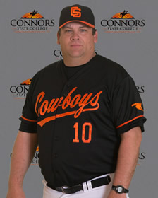 Head Coach of Connors State Softball, Bobby Foreman, stands in front of a Connors backdrop to pose for a headshot.
