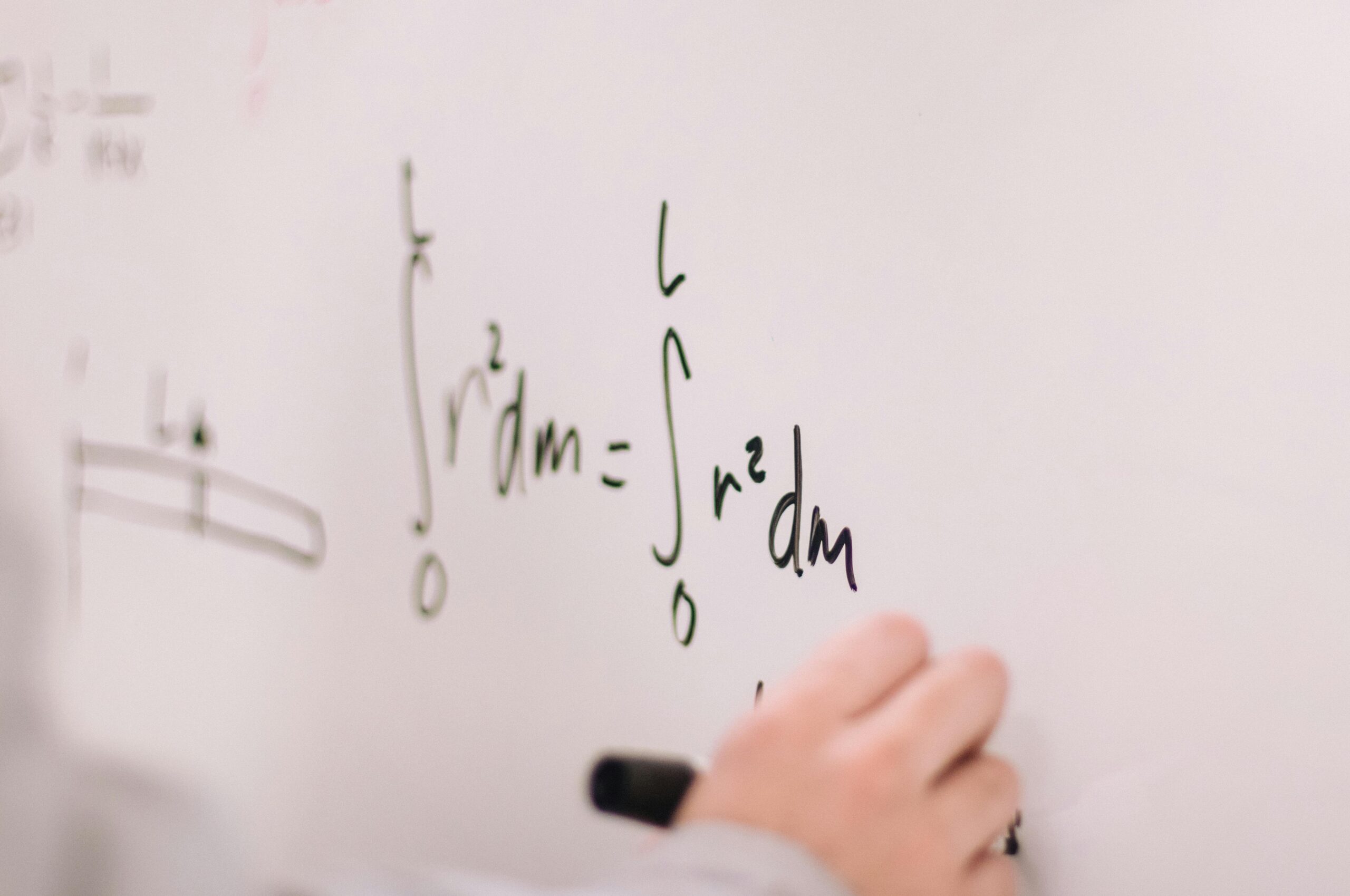 An image of a mathematic equation written with a black dry-erase marker on a whiteboard.